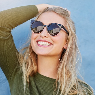 Woman with flawless smile after adult orthodontics treatment