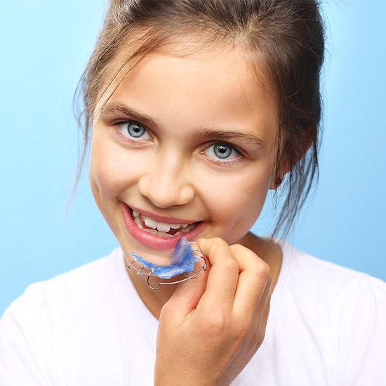 Young girl placing an orthodontic appliance