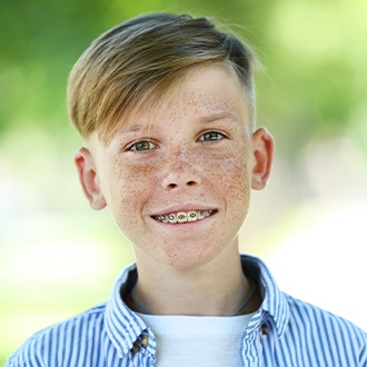 Smiling boy receiving pediatric orthodontic treatment