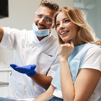 Patient and orthodontist smiling at image on screen
