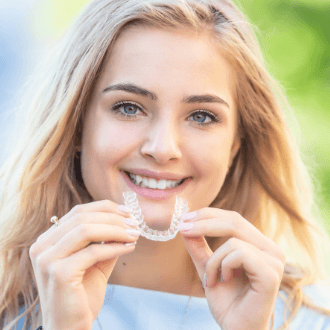 Teen girl placing Invisalign tray