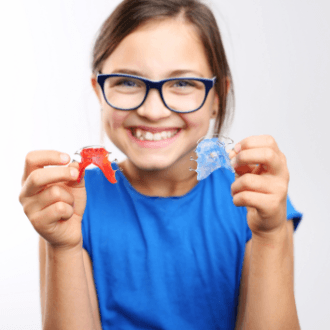 Teen girl holding up orthodontic appliances