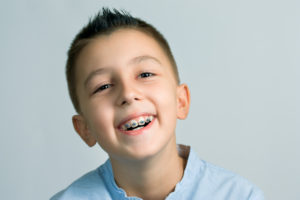 Closeup of smiling boy with pediatric orthodontics