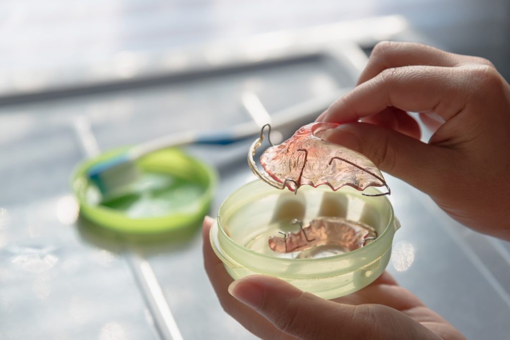 Patient placing retainer in storage case